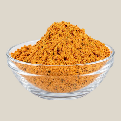 TuanaShop BV Fajita Kruiden Speciaal in een glazen kommetje, een aromatische oranje Tex-Mex kruidenmix voor gerechten.