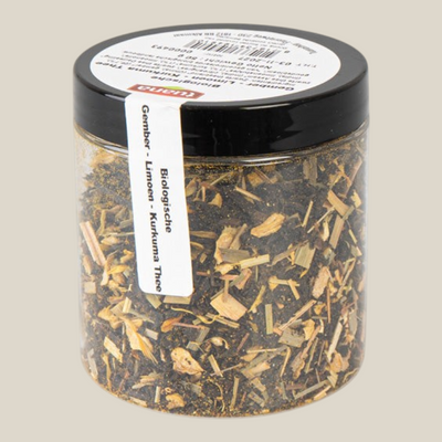 TuanaShop BV Gember Limoen Kurkuma thee in een doorzichtige pot met zwarte deksel en ingrediëntenlabel
