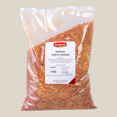 TuanaShop BV Dipper Pesto Rosso kruidenmix in een doorzichtige zak van 1 kg met rode en groene mediterrane kruiden.