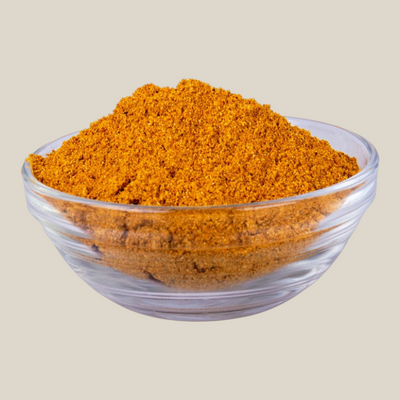 TuanaShop BV gele biryani kruidenmix in een glazen schaaltje met een rijke goudgele kleur en aromatische textuur.