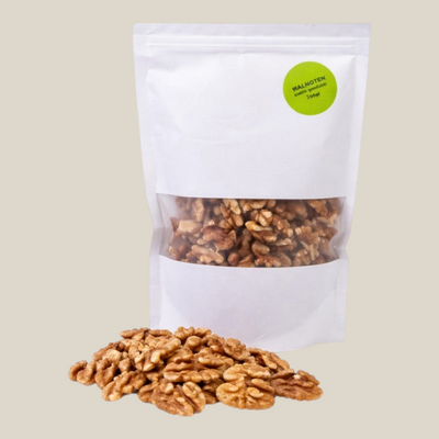 TuanaShop BV premium walnoten in een witte stazak met venster, vers en ongebrand voor een gezonde snack.