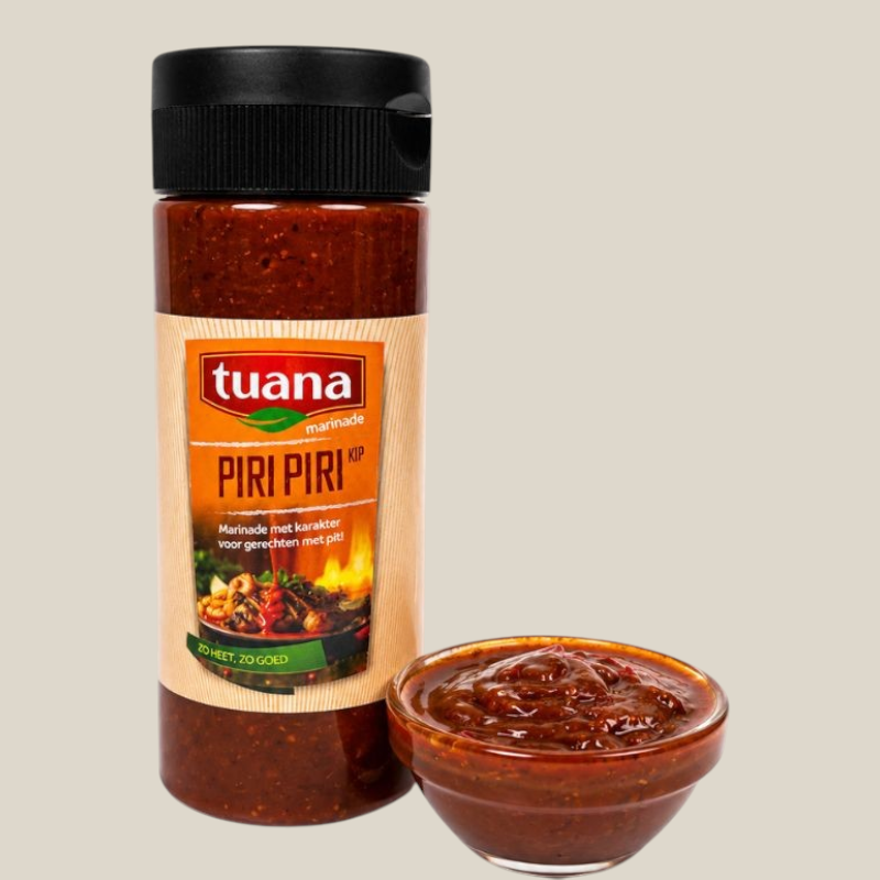 TuanaShop BV Piri Piri marinade in een fles met een schaaltje pittige rode saus voor vlees en groenten