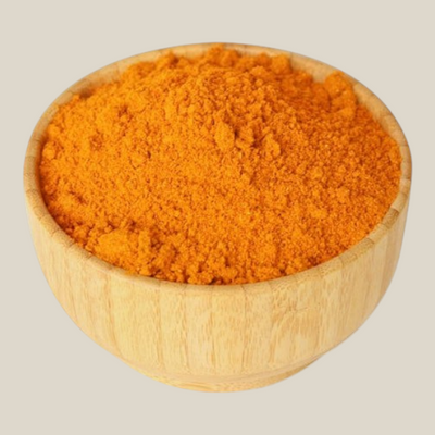 TuanaShop BV Thaise curry kruidenmix in een houten kom met een levendige oranje kleur en fijne textuur.